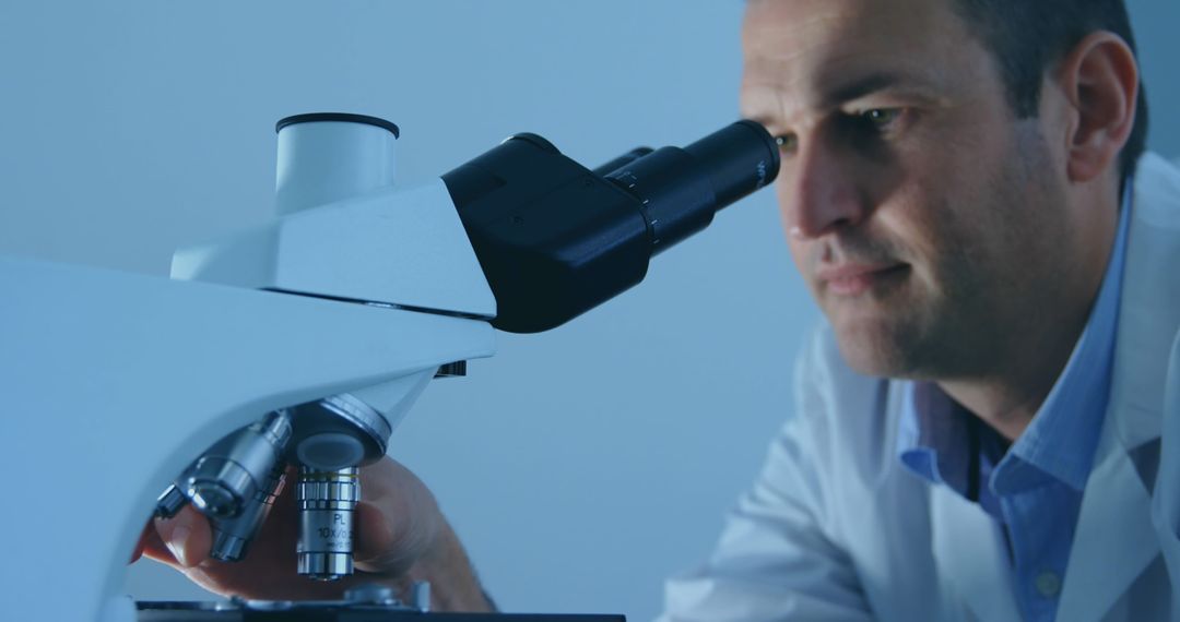 Scientist Inspecting Microscope Sample with Intense Focus