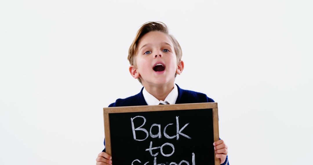 Excited Boy Holding Back to School Chalkboard - Free Images, Stock Photos and Pictures on Pikwizard.com