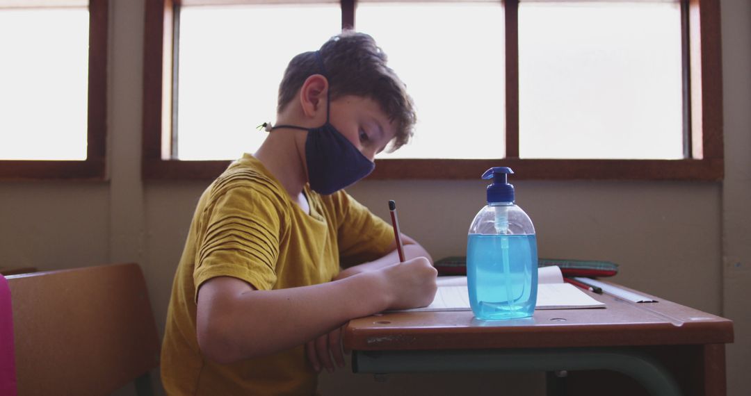 Young Boy Wearing Mask Doing Schoolwork in Classroom - Free Images, Stock Photos and Pictures on Pikwizard.com