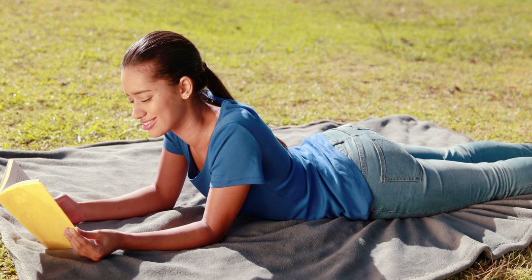 Young Woman Reading Book Outdoors on Blanket in Sunshine - Free Images, Stock Photos and Pictures on Pikwizard.com