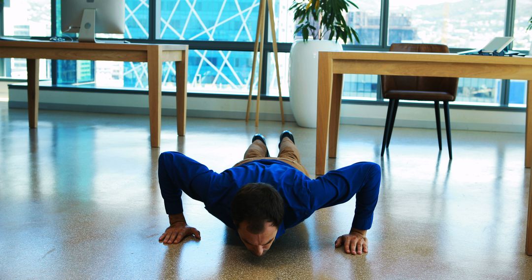 Businessman Doing Push-Ups in Modern Office - Free Images, Stock Photos and Pictures on Pikwizard.com