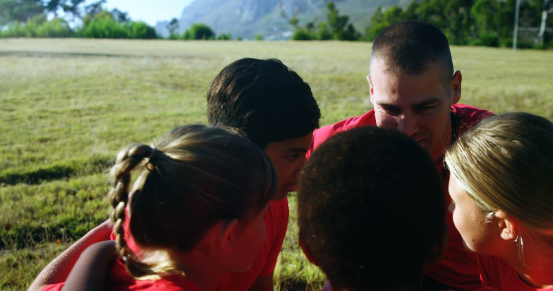 Motivated Coach Encouraging Team Unity in Sunny Outdoors Boot Camp