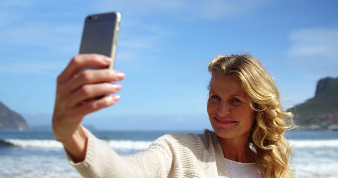 Smiling Woman Taking Selfie on Beach - Free Images, Stock Photos and Pictures on Pikwizard.com