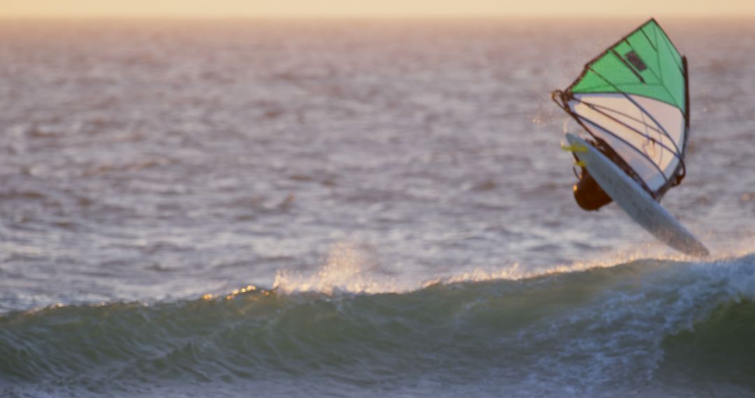 Windsurfer Catching A Wave During Sunset On The Ocean - Free Images, Stock Photos and Pictures on Pikwizard.com