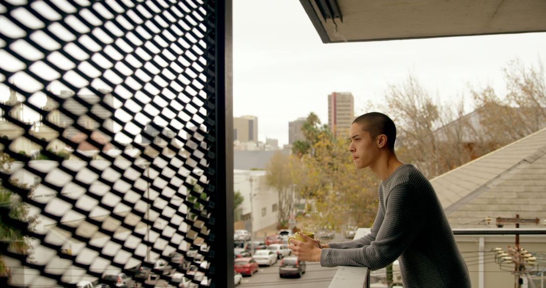 Young Man on Balcony Overlooking City Traffic with Smartphone - Free Images, Stock Photos and Pictures on Pikwizard.com