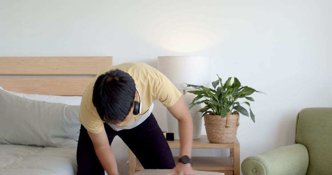 Man Packing Cardboard Box Indoors with Headphones