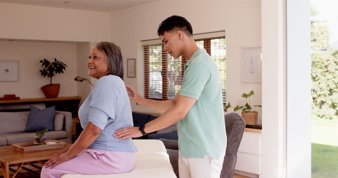 Male Physiotherapist Assisting Senior Woman with Back Therapy
