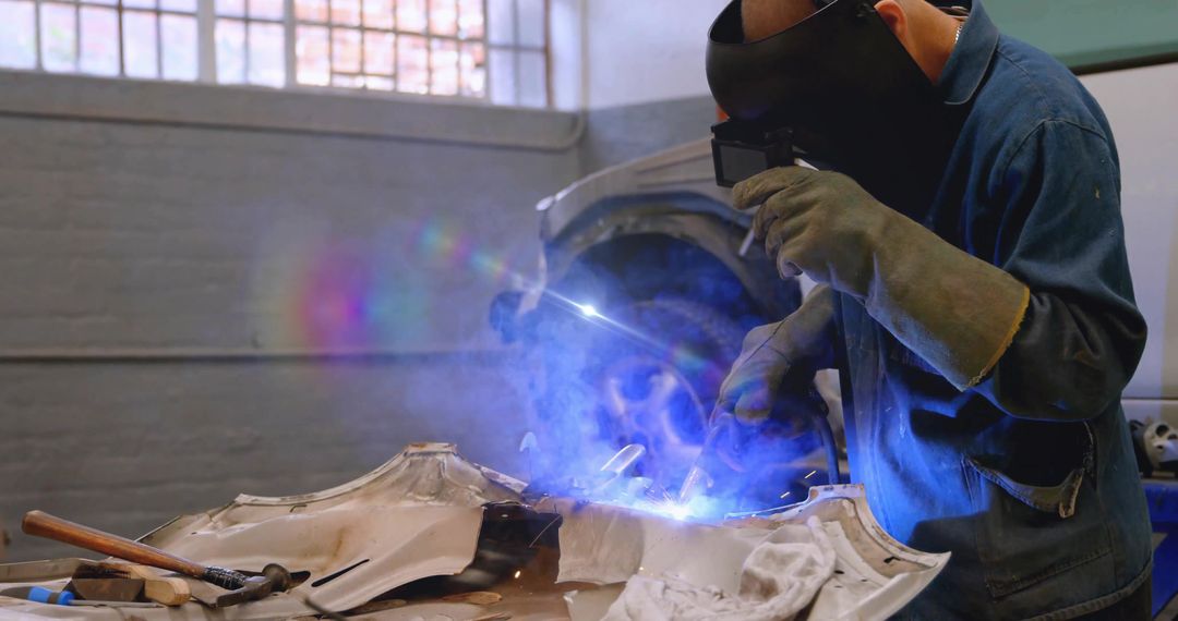 Welding Technician Repairing Vehicle Panel in Workshop