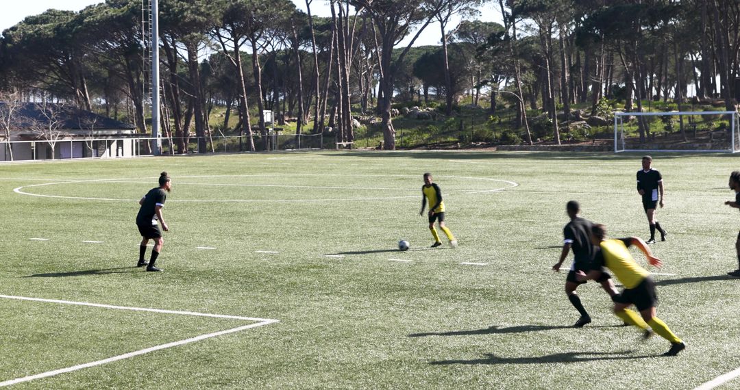 Soccer Match with Players in Black and Yellow Uniforms on Field