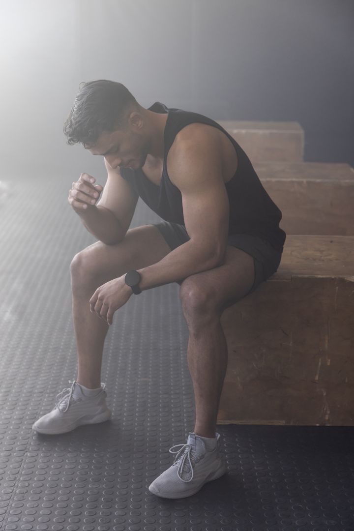 Athletic Man Resting on Plyometric Box After Intense Workout