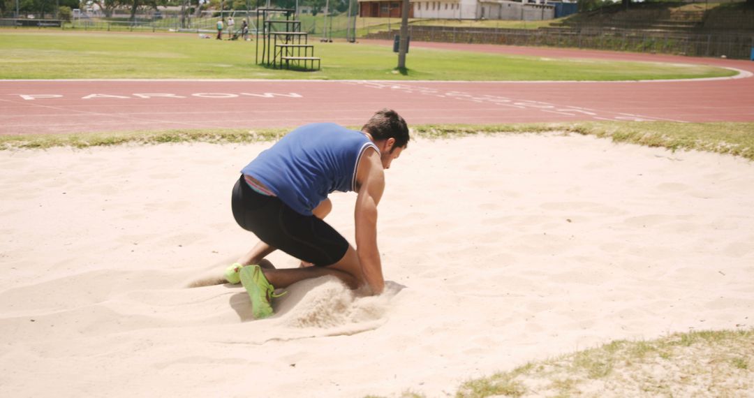 Athlete Practicing Long Jump Landing in Sand Pit on Track Field - Free Images, Stock Photos and Pictures on Pikwizard.com