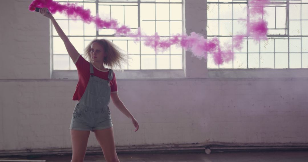 Young Woman Playing with Pink Smoke in Loft Setting - Free Images, Stock Photos and Pictures on Pikwizard.com