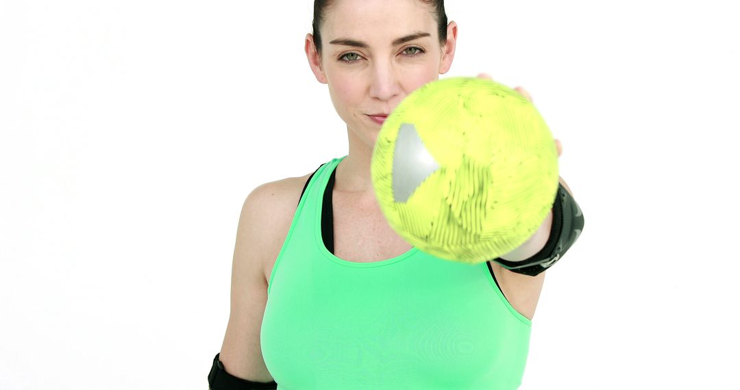 Confident Woman Holding Yellow Ball in Green Sportswear - Free Images, Stock Photos and Pictures on Pikwizard.com