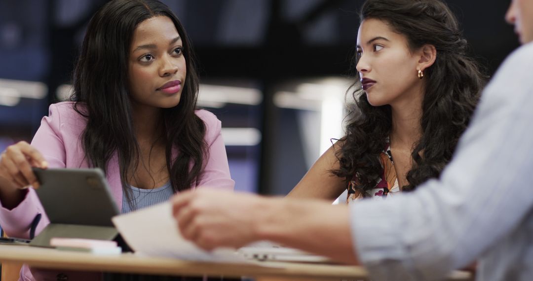 Diverse Colleagues Using Tablet and Collaborating in Office Setting