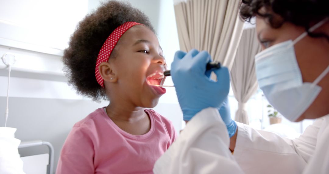 Child Receiving Throat Examination from Doctor Wearing Mask and Gloves - Free Images, Stock Photos and Pictures on Pikwizard.com