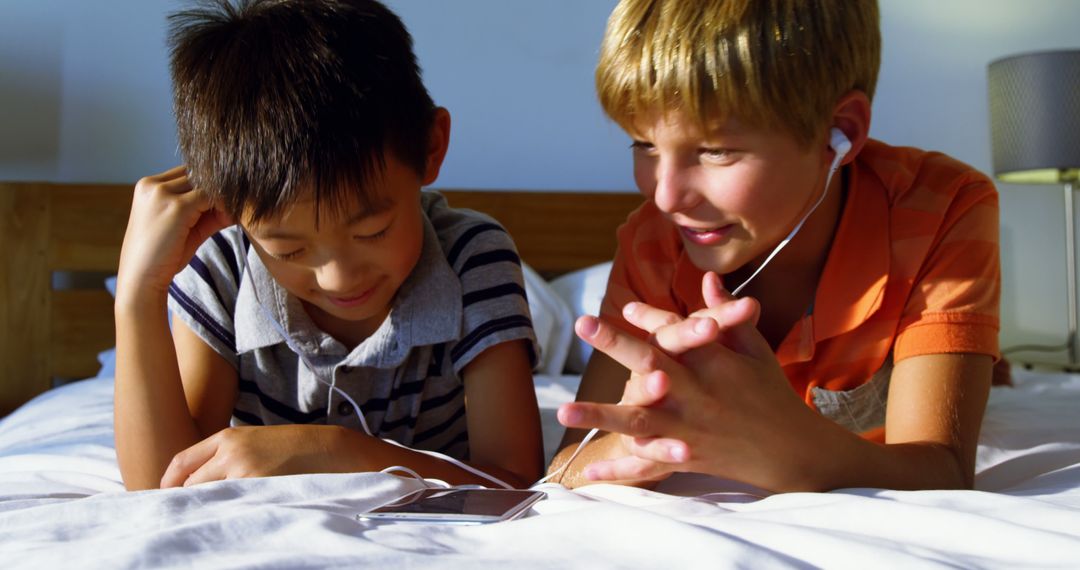 Two Children Listening to Music in Bed Sharing Earbuds - Free Images, Stock Photos and Pictures on Pikwizard.com