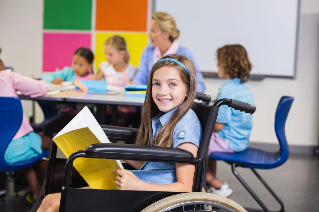 Disabled school girl on wheelchair holding a book in classroom - Free Images, Stock Photos and Pictures on Pikwizard.com