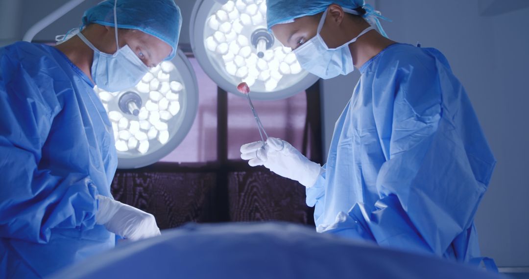 Two surgeons discuss a patient during surgery in an operating theatre. - Free Images, Stock Photos and Pictures on Pikwizard.com