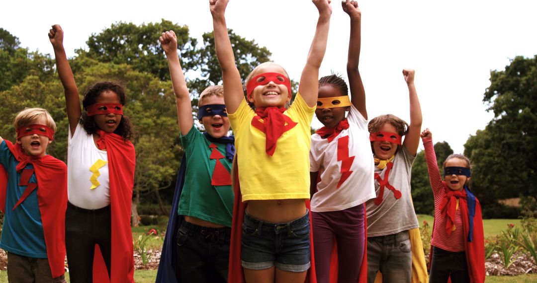 Diverse Group of Children Dressed as Superheroes Raising Arms Outdoors - Free Images, Stock Photos and Pictures on Pikwizard.com