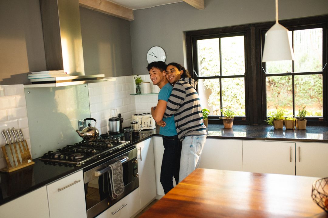 Happy Multiracial Gay Couple Embracing in Modern Kitchen - Free Images, Stock Photos and Pictures on Pikwizard.com