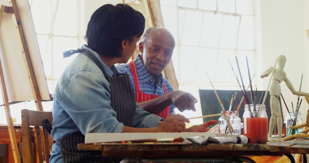 Senior Artist Teaching Painting to Younger Man in Art Studio - Free Images, Stock Photos and Pictures on Pikwizard.com