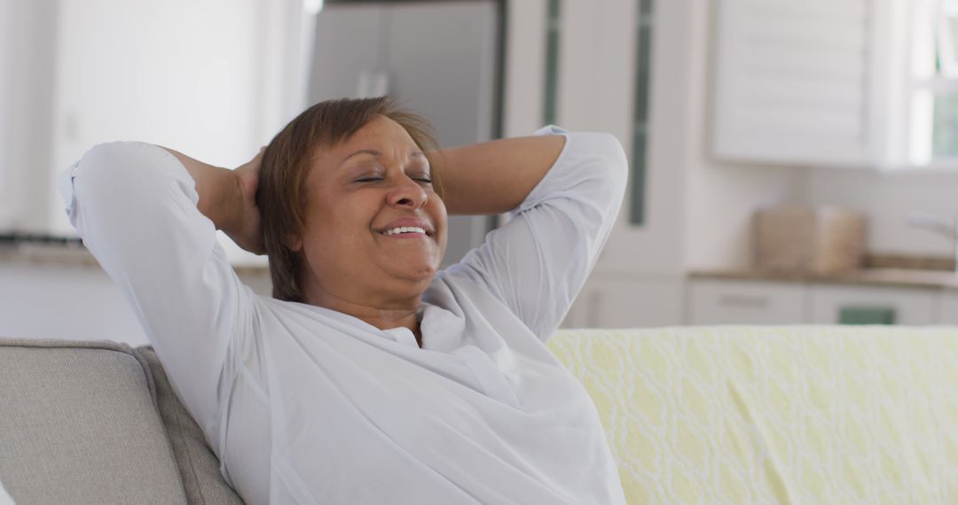 Smiling Woman Relaxing on Couch at Home - Free Images, Stock Photos and Pictures on Pikwizard.com