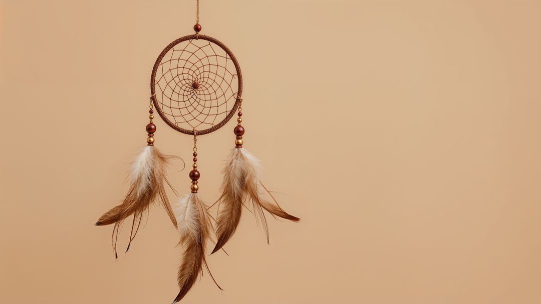 Hanging Dreamcatcher with Feathers and Beads Against Neutral Background
