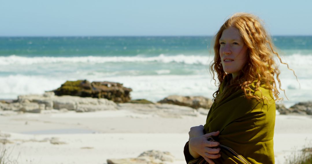 Red-haired Woman Standing on Beach Wrapped in Green Shawl - Free Images, Stock Photos and Pictures on Pikwizard.com