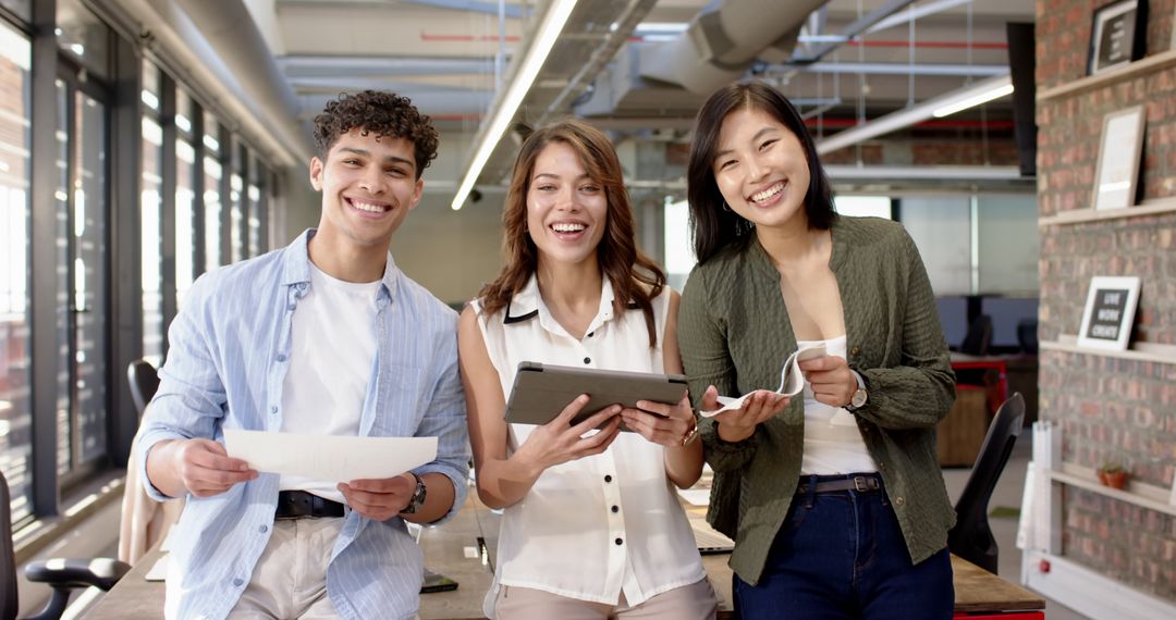 Diverse Coworkers Smiling with Devices in Modern Office Space
