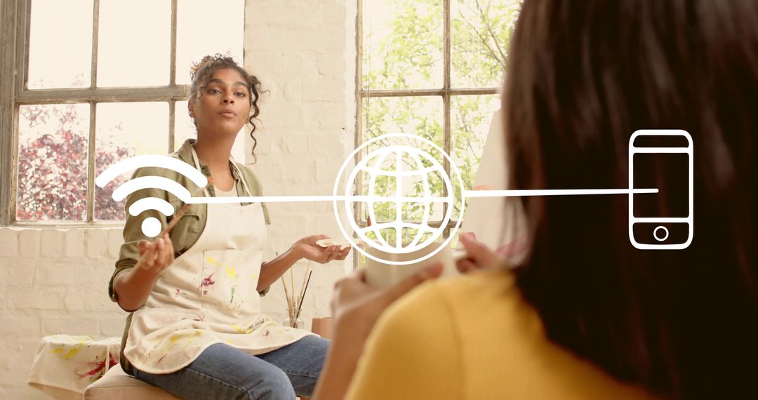 Artist gesturing in sunlit studio teaching with Wi-Fi and mobile connection graphic
