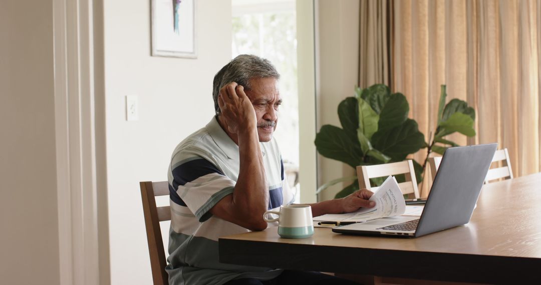 Elderly Man Analyzing Financial Documents at Home - Free Images, Stock Photos and Pictures on Pikwizard.com