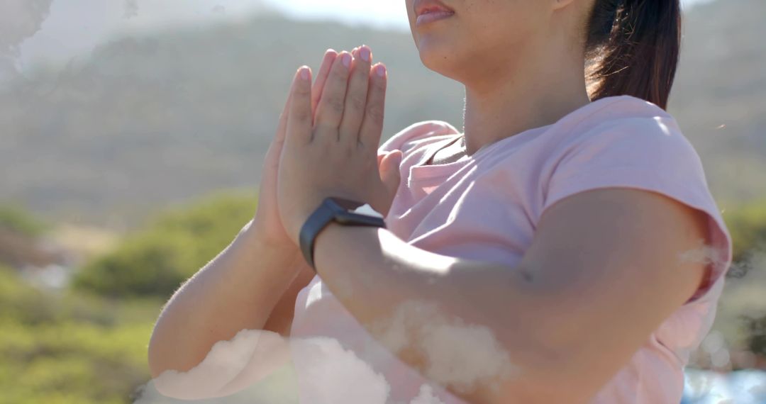 Serene asian woman practicing mindfulness outdoors with smartwatch