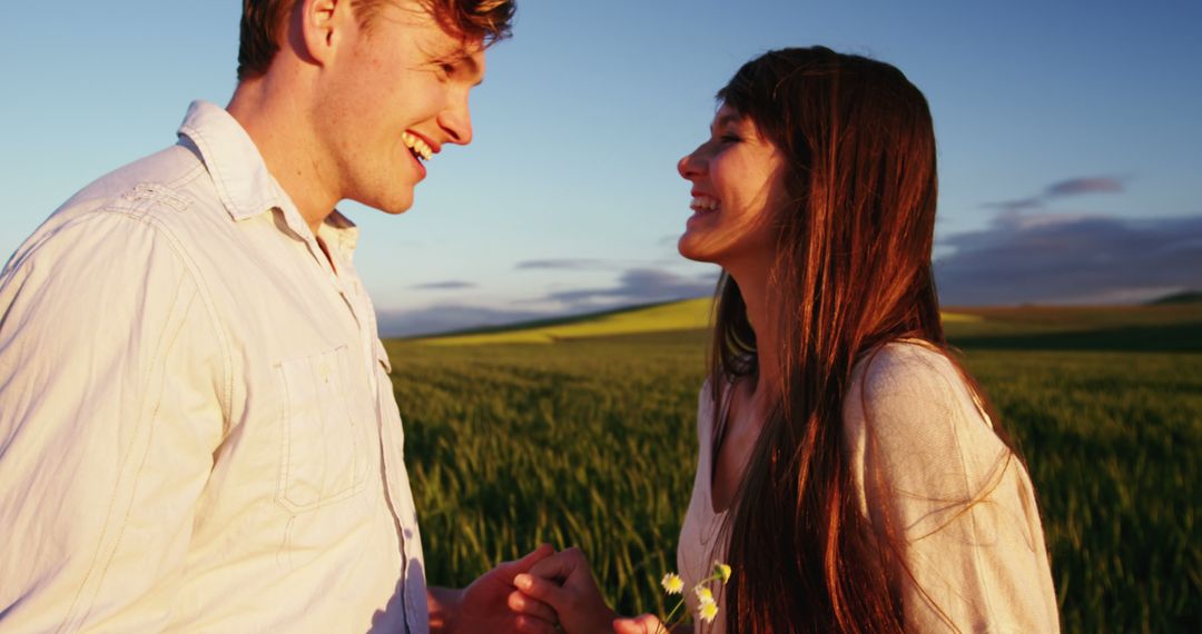 Happy Couple Holding Hands Smiling in Countryside Golden Hour - Free Images, Stock Photos and Pictures on Pikwizard.com