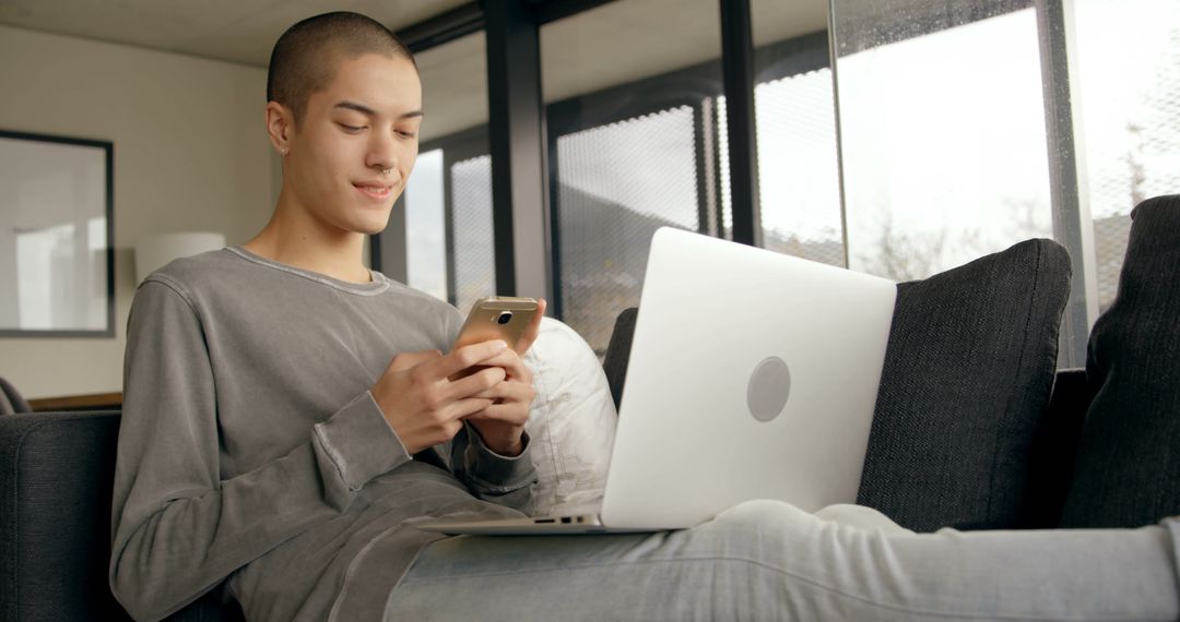 Young Man Using Smartphone and Laptop Hassle-Free at Home - Free Images, Stock Photos and Pictures on Pikwizard.com