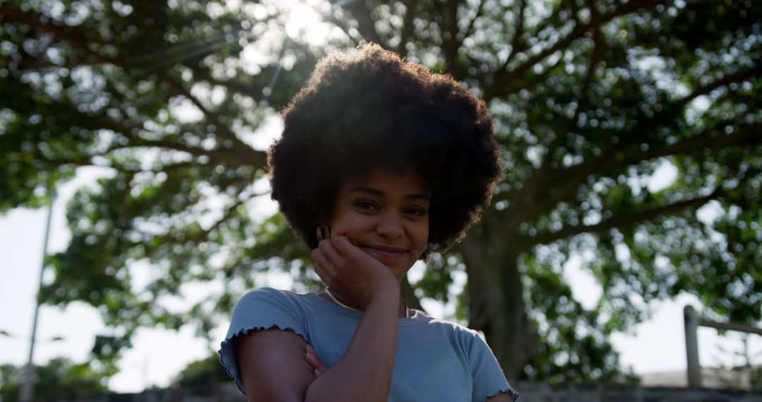 Smiling Woman with Natural Hair Standing Outdoors - Free Images, Stock Photos and Pictures on Pikwizard.com