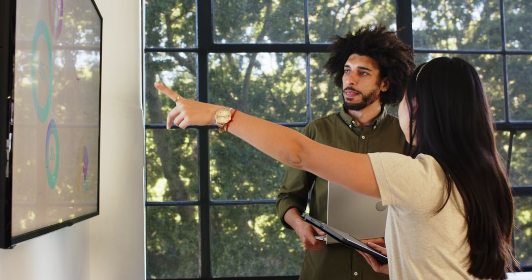 Colleagues Collaborating on Digital Presentation in Modern Office