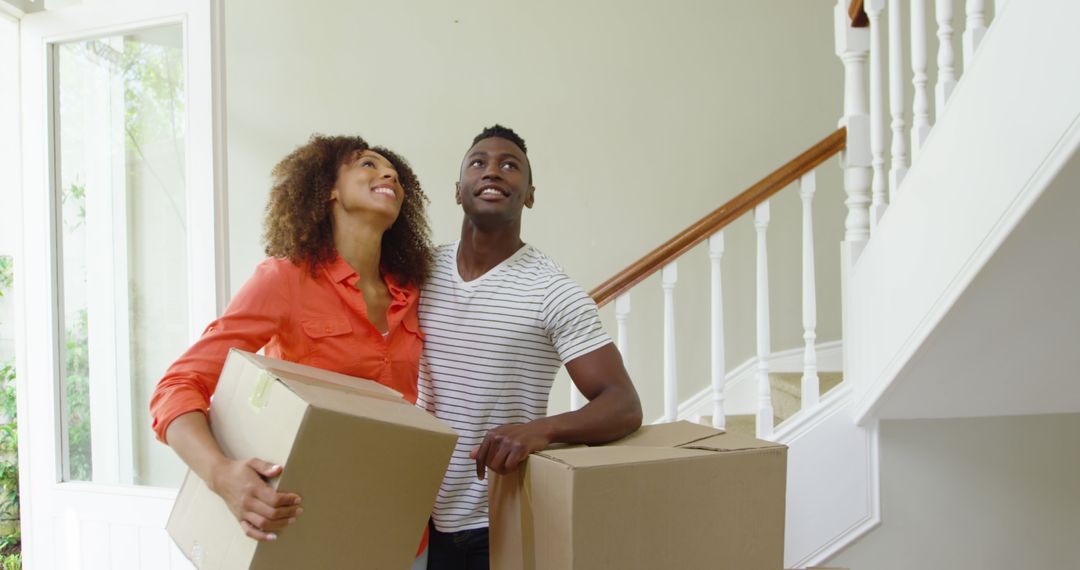 Happy Couple Moving into New Home with Cardboard Boxes