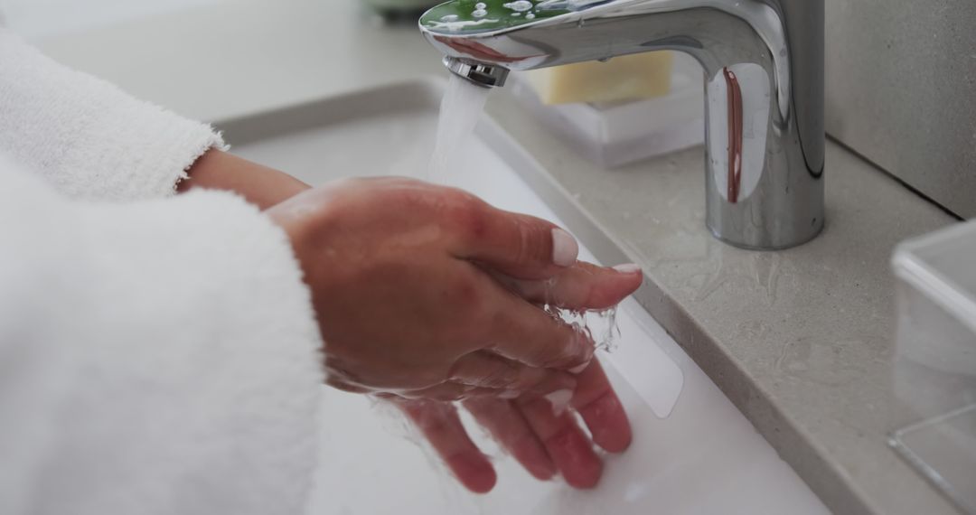 Person Washing Hands Under Running Water in Modern Bathroom - Free Images, Stock Photos and Pictures on Pikwizard.com