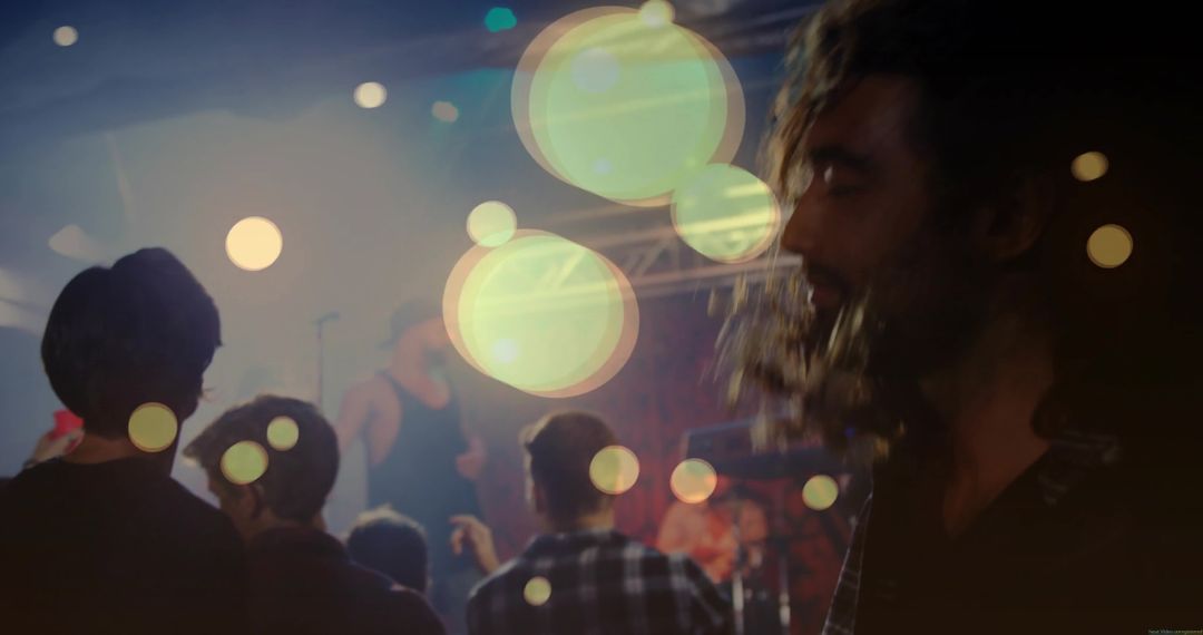Bearded Man Enjoying Live Nightclub Concert with Bokeh Lights