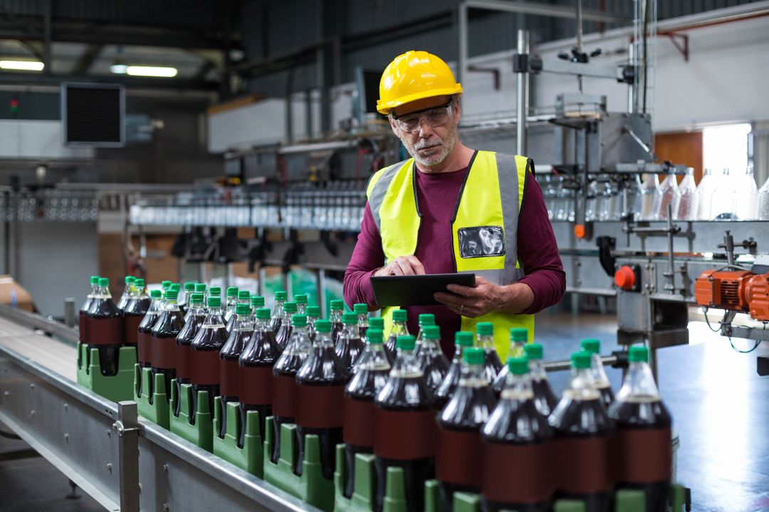 Factory Worker Inspecting Production Line with Tablet Technology