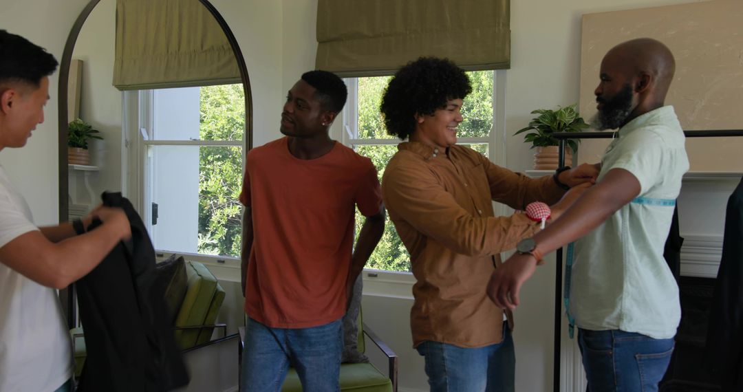 Tailor Measuring Chest for Custom Suit While Friends Helping in Sunlit Living Room