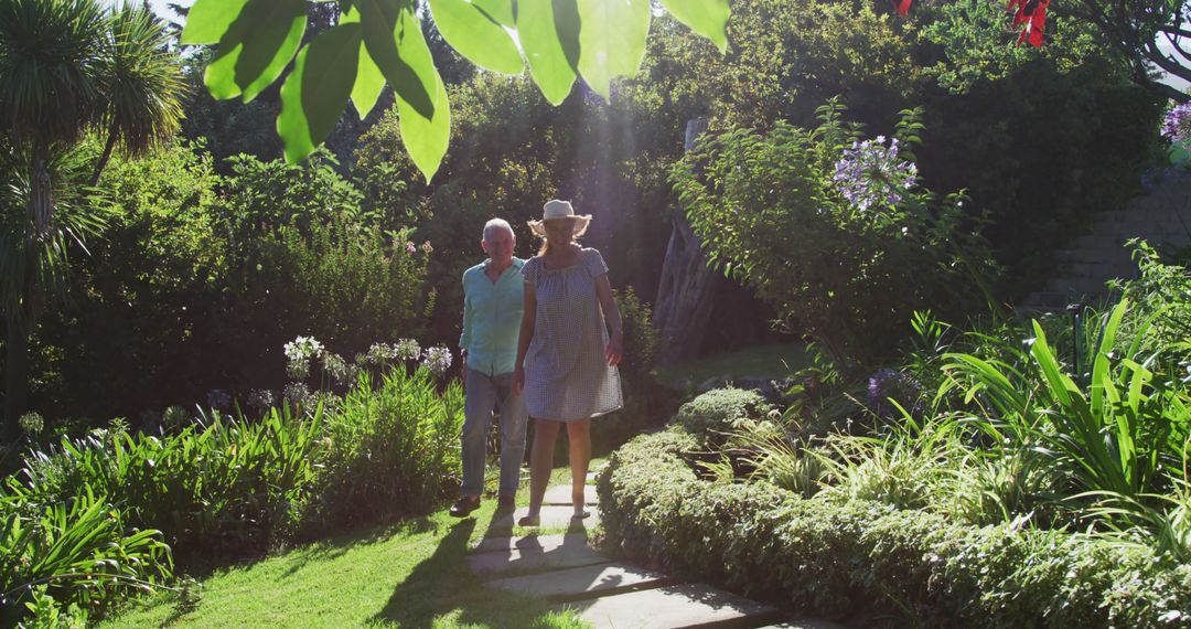 Caucasian senior couple walking in garden together in the sun - Free Images, Stock Photos and Pictures on Pikwizard.com