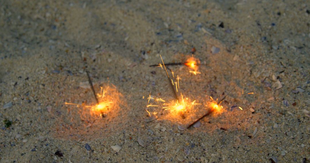 Vibrant Sparklers Glowing on Beach Sand at Night - Free Images, Stock Photos and Pictures on Pikwizard.com