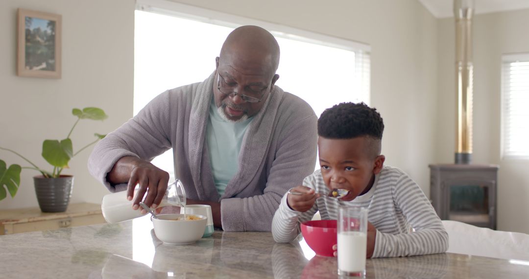 Grandfather Pouring Milk for Grandson's Breakfast Cereal in Kitchen - Free Images, Stock Photos and Pictures on Pikwizard.com