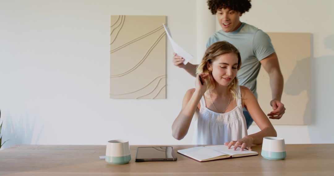 Young Couple Collaborating at Table with Notebooks and Coffee