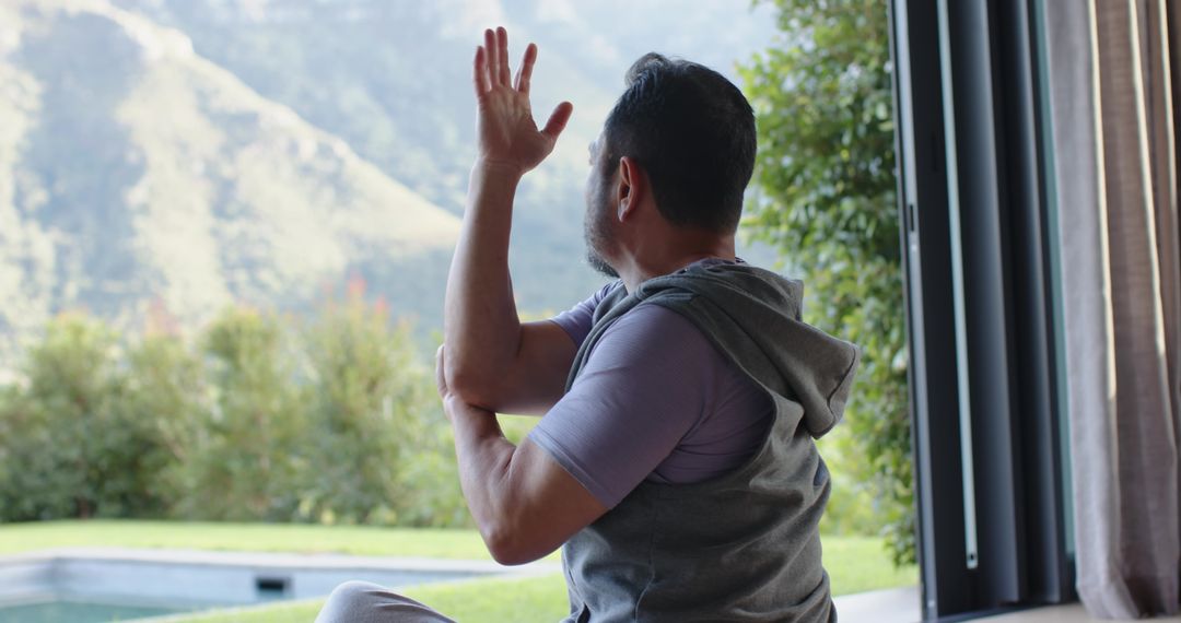 Man Practicing Yoga on Terrace Overlooking Scenic Hillside