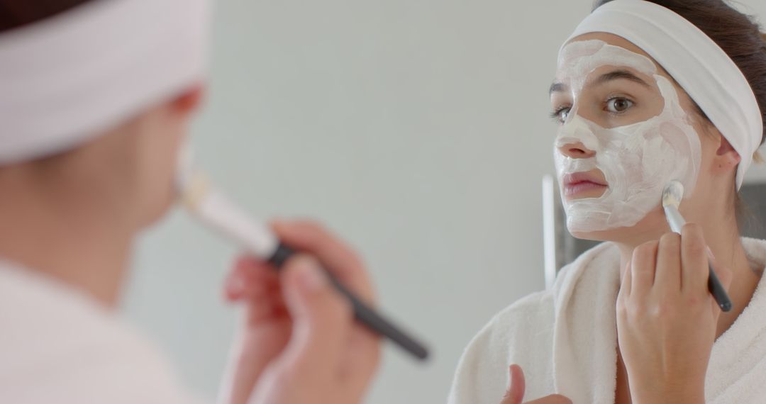 Woman Applying Facial Mask in Minimalist Bathroom Mirror Reflection