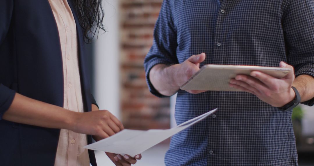 Diverse Colleagues Discussing Technology and Documents