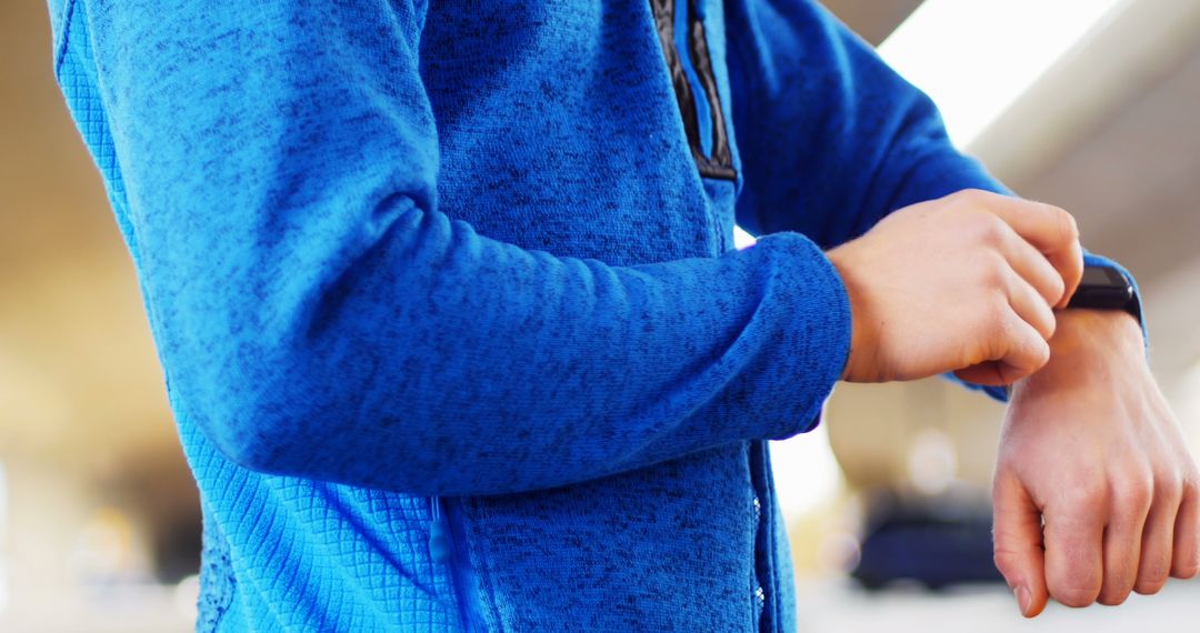 Athlete Checking Smartwatch During Workout in Blue Sports Jacket - Free Images, Stock Photos and Pictures on Pikwizard.com