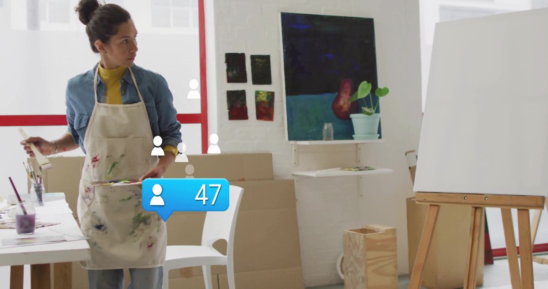 Artist Mixing Paint on Palette in Creative Studio with Canvas